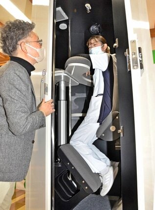 立ったまま寝る仮眠ボックスの使い心地を確かめる看護師＝鳥取県日南町生山、日南病院