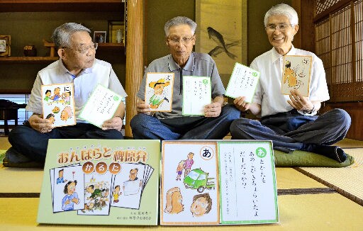 完成した稗原弁のかるたを手にする会員の花田恵一さん、金山富憲さん、石野真さん（左から）＝出雲市稗原町