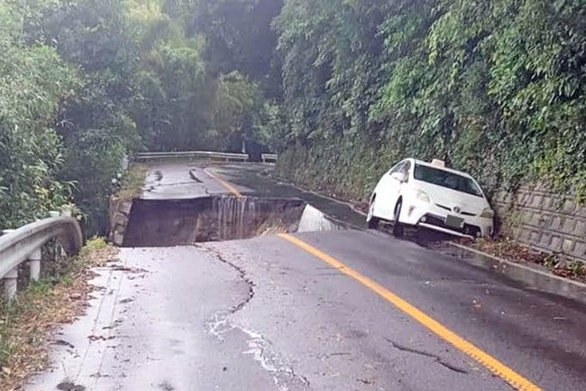 豪雨で陥没した県道＝9日午後、出雲市大社町日御碕（読者提供）