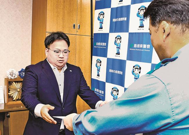 上野訓生署長（右）から感謝状を受け取る榎並孝亮さん＝島根県隠岐の島町西町、隠岐の島署