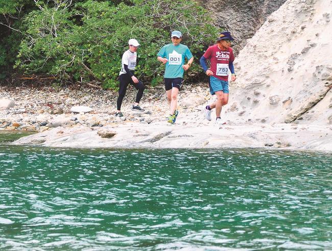 海岸沿いの岩場を走る選手＝大田市温泉津町温泉津、櫛島キャンプ場