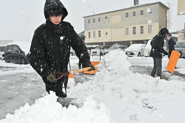 駐車場の雪かきをする男性＝１９日午前９時５０分ごろ、米子市東福原２丁目