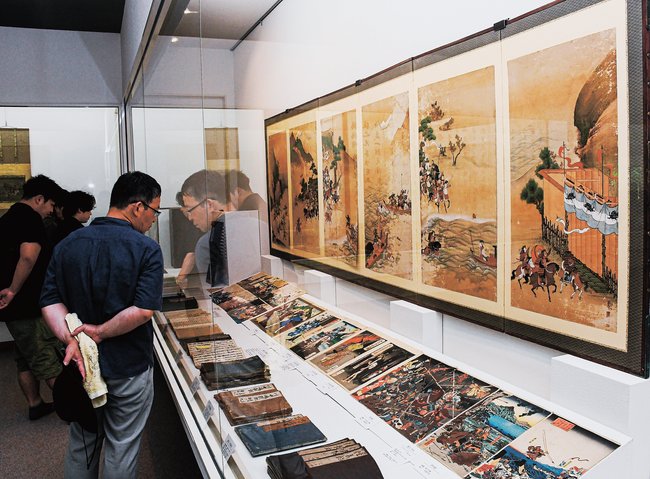 展示品の軍記などを鑑賞する来館者＝島根県奥出雲町上阿井、可部屋集成館