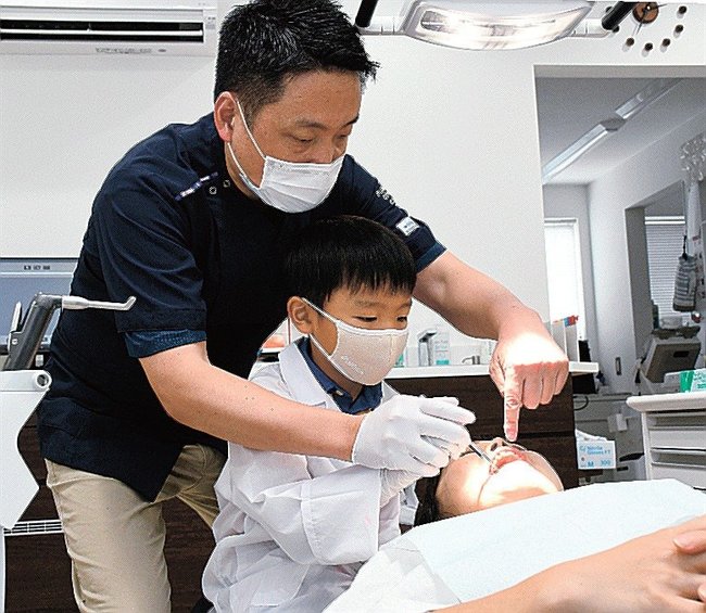 歯科医師の指示で歯の本数を数える児童＝島根県邑南町矢上、藤本歯科医院
