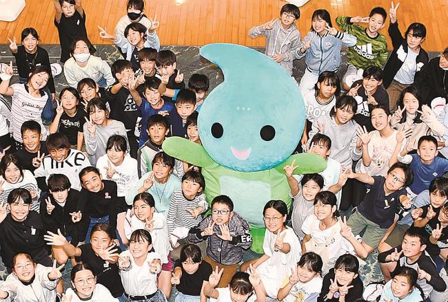 新調された「よすみちゃん」と記念撮影をする大津小学校の児童＝出雲市大津町、出雲弥生の森博物館