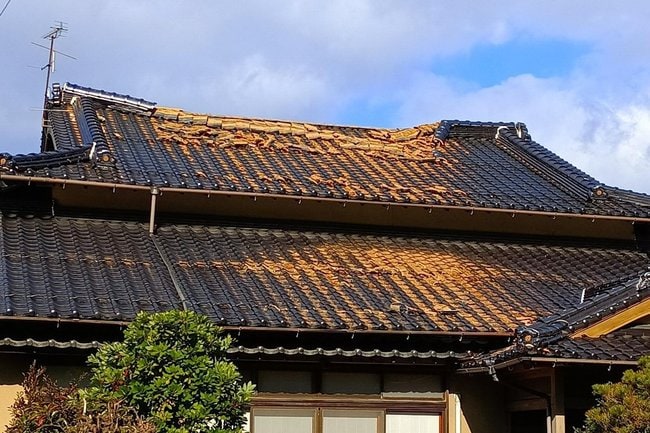 地震の影響で屋根瓦が落ちた家屋＝午後0時30分、松江市東出雲町揖屋