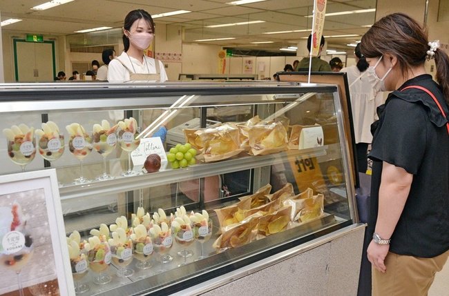 二十世紀梨やイチジクのスイーツを眺める来場者（右）＝米子市西福原２丁目、米子しんまち天満屋