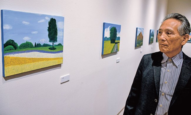 「花回廊」（左）など明るい油彩画を描く秦野良二さん＝鳥取市丸山町、ギャラリー３３０