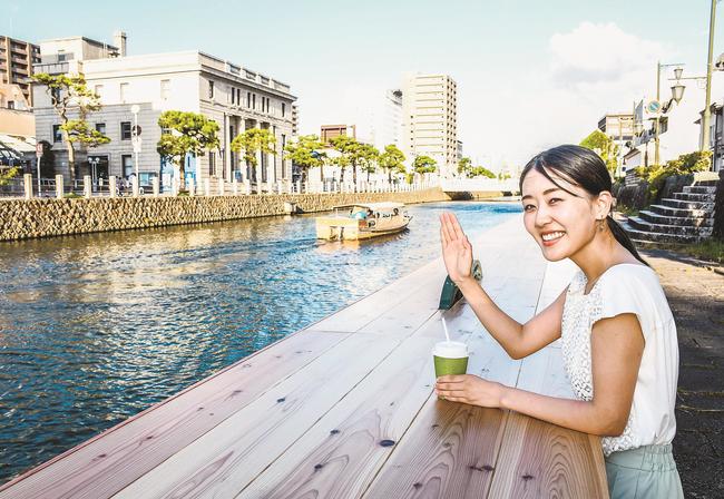 設置されたテラスから堀川遊覧船に向かって手を振る関係者＝松江市片原町