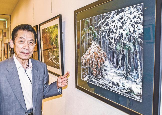 丁寧に描き込んだ風景画を紹介する高見秋彦さん＝出雲市今市町、ラピタ本店