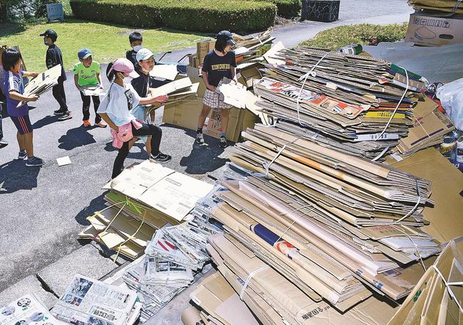 町内から回収した大量の段ボールや新聞紙、空き缶を積み上げる児童＝島根県邑南町下口羽、口羽小学校
