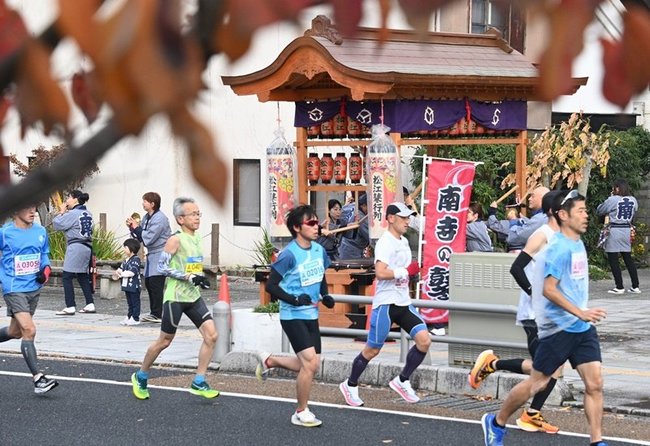 鼕台の前を走り抜けるランナー＝松江市寺町