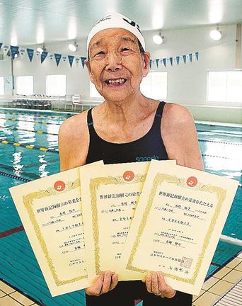 世界記録の認定書を手にする木村悦子さん＝出雲市渡橋町、ＪＳＳスイミングスクール出雲