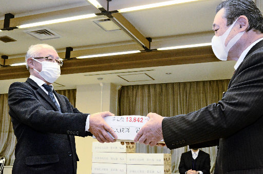 署名簿を提出する河合康明共同代表（左）＝米子市加茂町１丁目、市役所
