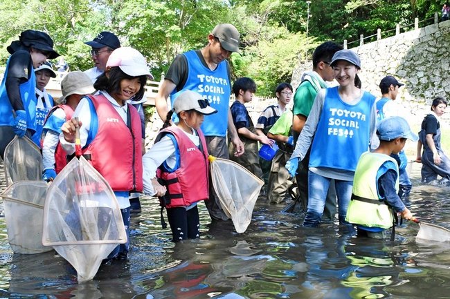 たもを持ち、生き物を探す参加者＝松江市殿町、堀川