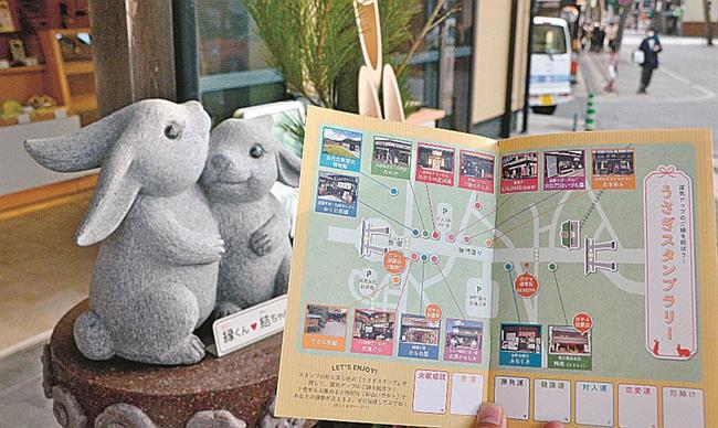 神門通りの店舗に並ぶウサギの像と周遊を促すガイドブック「出雲之国遊歩手帖」＝出雲市大社町杵築南