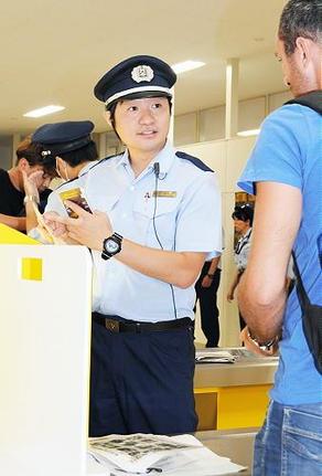 入国した外国人旅行者に手荷物の内容を尋ねる神戸税関境税関支署の加藤薫樹監視官。仕事を通して「日本の治安維持に貢献したい」と話す＝境港市昭和町