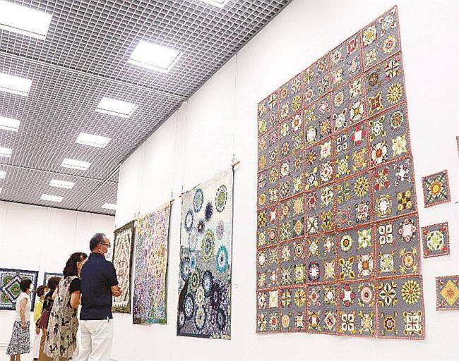 パッチワークキルトの大作に見入る来館者＝松江市袖師町、島根県立美術館