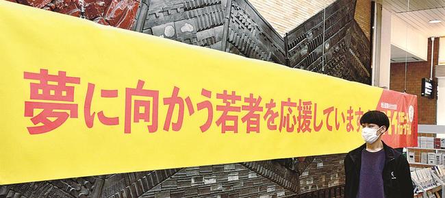 若者の門出を祝おうと掲げられた横断幕＝松江市朝日町、ＪＲ松江駅