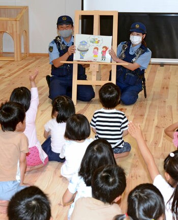紙芝居を用いて交通安全指導をする新田遼平巡査部長（左）と桂子巡査長‖松江市八雲町西岩坂、社会福祉法人ひよし福祉会ひよし保育園