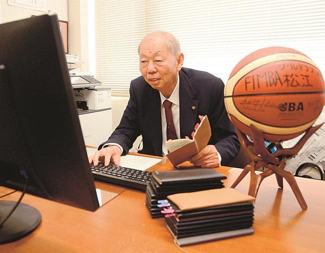 手帳で球団設立時の思い出を振り返りながら、原稿を執筆する藤井三千勇さん＝松江市東津田町、藤井基礎設計事務所