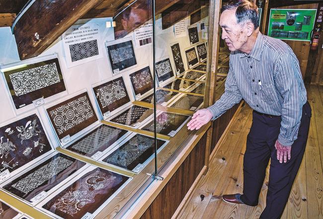 多彩なデザインの藍染めの型紙を紹介する隅田正三館長＝浜田市金城町波佐、金城歴史民俗資料館
