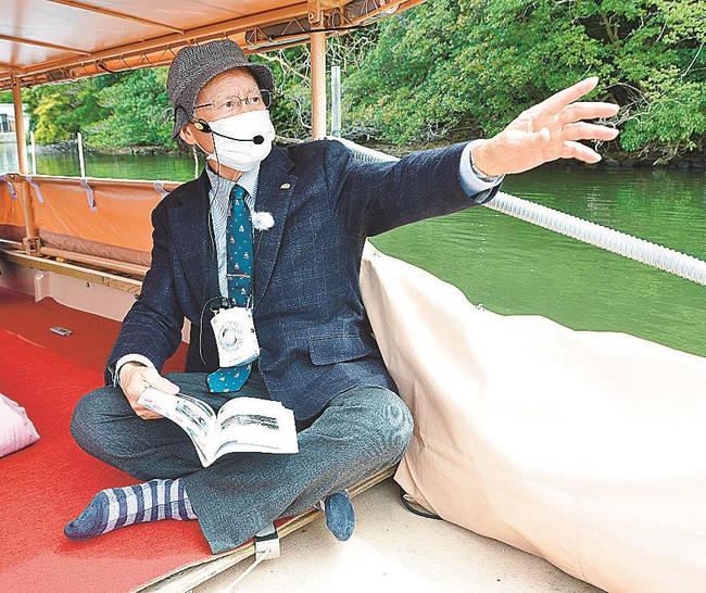 堀川遊覧船で松江城や城下町の歴史を解説する宍道正年さん＝松江市内
