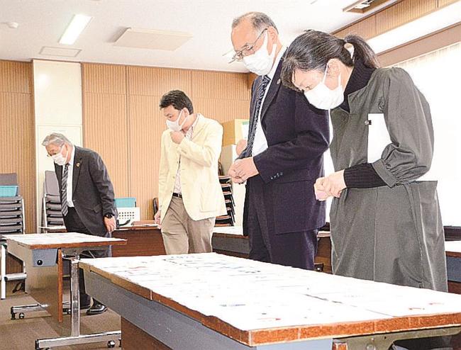 ロゴマークの応募作品を眺める審査員＝松江市西川津町、島根大