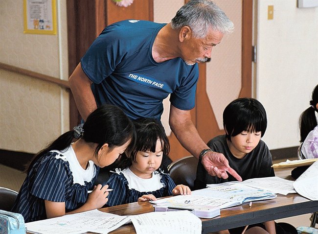 元教員の助言を得ながら自由研究の計画を立てる児童たち＝島根県邑南町高見、高原公民館