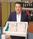浜田市内の学校給食で提供する「どんちっちノドグロ」を手にする金坂敏弘会長＝浜田市殿町、市役所