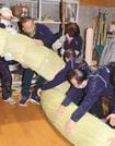 ２本の太い縄をより合わせる組合員たち＝島根県飯南町花栗、町大しめなわ創作館