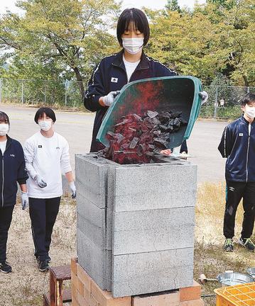 炉に木炭を入れる生徒＝島根県奥出雲町稲原