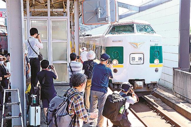 ＪＲ出雲市駅に到着した緑やくもを撮影する鉄道ファン＝出雲市駅北町