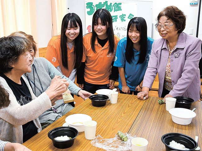 うずめ飯の食べ比べで交流する生徒と参加者＝益田市高津５丁目、浜集会所