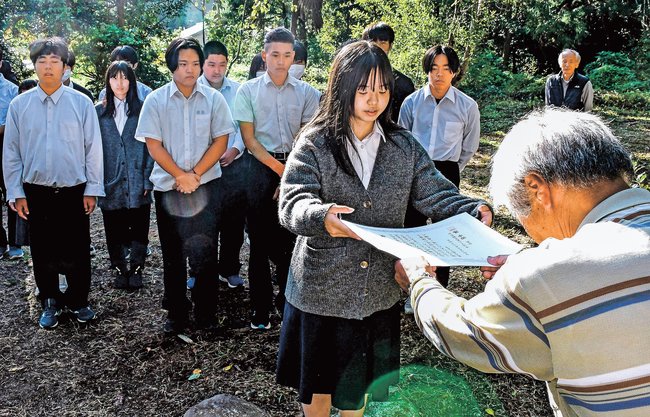 顕彰会会員（右）から感謝状を託される代表生徒＝島根県隠岐の島町中村