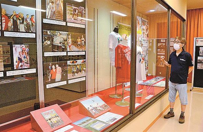 第１回大会の写真など展示品を説明する皆生トライアスロン協会の高木均副競技委員長＝米子市皆生温泉３丁目、市観光センター