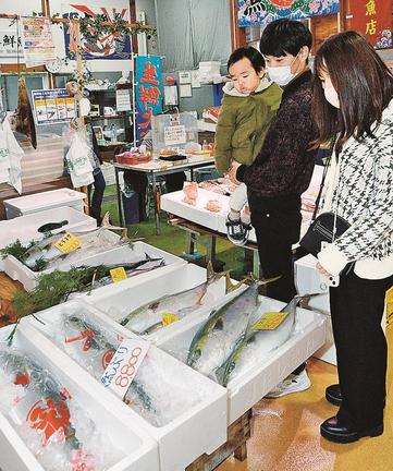 ブリの品定めをする買い物客＝浜田市原井町、山陰浜田港公設市場