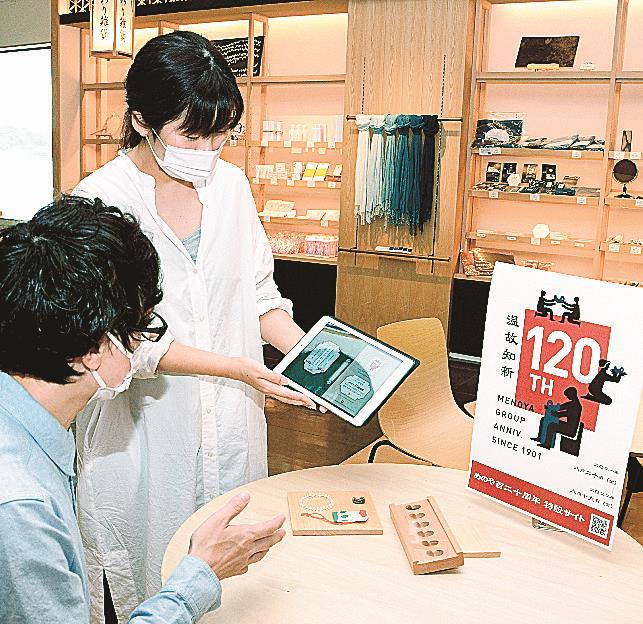 「めのや石倶楽部」を紹介するスタッフ（右）＝松江市玉湯町湯町、いずもまがたまの里伝承館