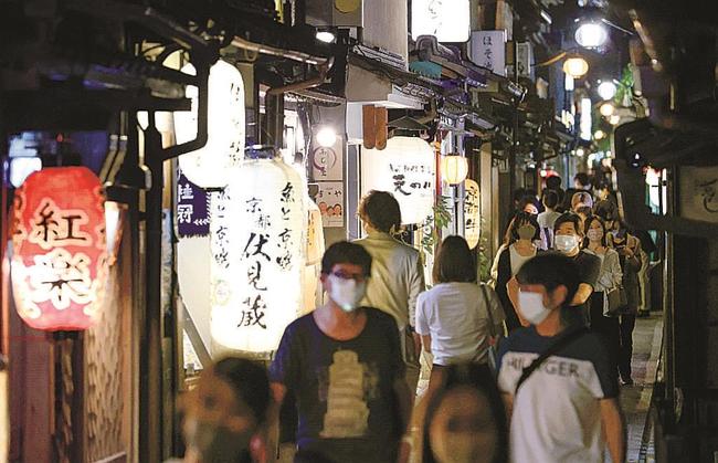 飲食店が並ぶ京都・先斗町をマスク姿で歩く人たち。日本料理店で働く男性は「きょうがこの１年で一番の人出。緊急事態宣言が終わり予約も入り始めている」と話した＝２日夜