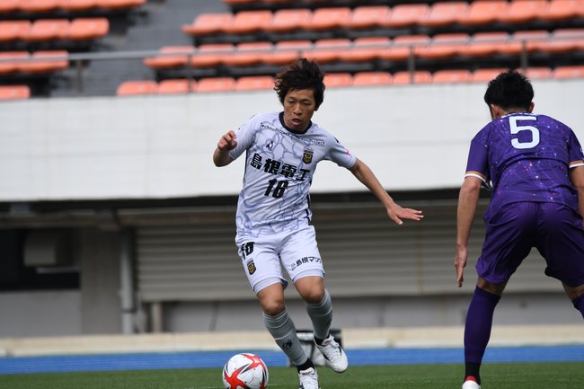 後半４分、ＦＣ神楽しまねのＭＦ高畑智也（左）がドリブルで攻め込み、今季チーム初となるゴールを決めた＝駒沢オリンピック公園総合運動場陸上競技場（東京都世田谷区）