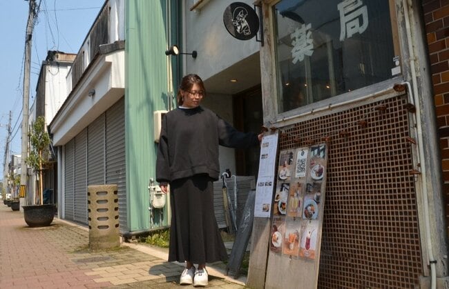 薬局だった空き店舗を活用したカフェと雑貨の複合店舗「みっくす」を拠点に商店街のにぎわいを生み出す亀井智子さん＝米子市日野町、元町通り商店街