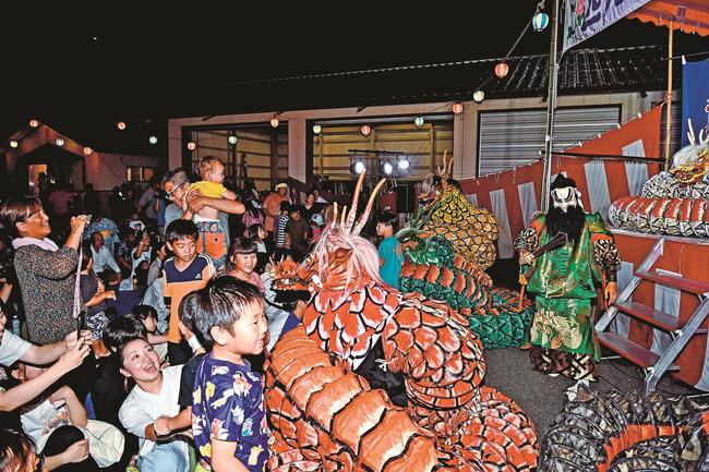 客席に降りた大蛇やスサノオノミコトを間近に見て楽しむ来場者＝益田市匹見町匹見、匹見タウンホール裏駐車場