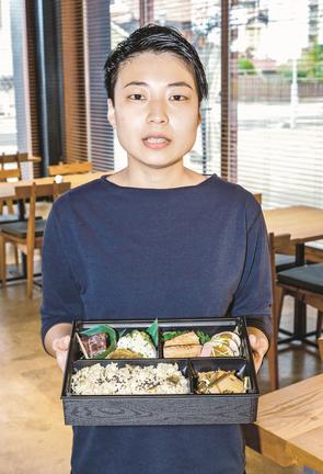 祝い膳をアレンジした弁当を手にする沢江はるなさん＝益田市駅前町、ＭＡＳＣＯＳ　ＢＡＲ＆ＤＩＮＩＮＧ