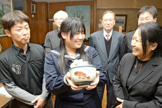 デザインした丼わんを手に完成を喜ぶ中村きおなさん（中央）と関係者＝浜田市黒川町、浜田高校
