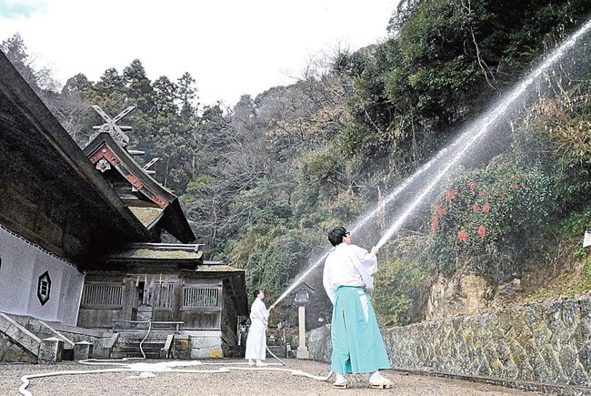 放水訓練をする美保神社の神職＝松江市美保関町美保関、美保神社