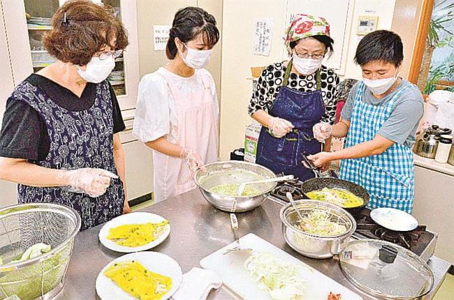 料理を教えるグエンティ・モンズンさん（右）とフィンティ・クェアンさん（左から２人目）＝松江市比津町、法吉公民館