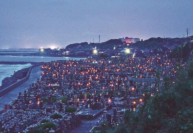 「迎え火」がともされた花見潟墓地＝鳥取県琴浦町赤碕