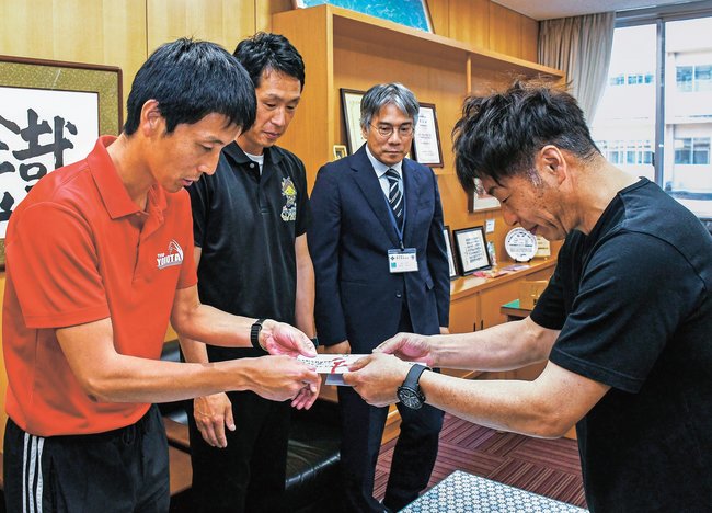 伊藤孝広社長から寄付金を受け取る伊藤直登監督（左）＝島根県奥出雲町稲原、横田高校