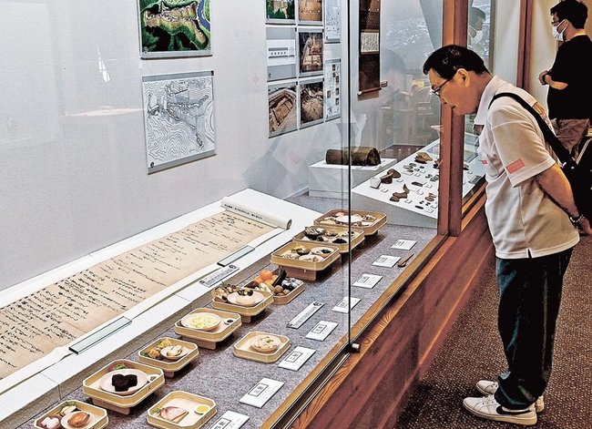 中世の食を再現した精巧なレプリカを鑑賞する来場者＝益田市本町、市立歴史文化交流館・れきしーな