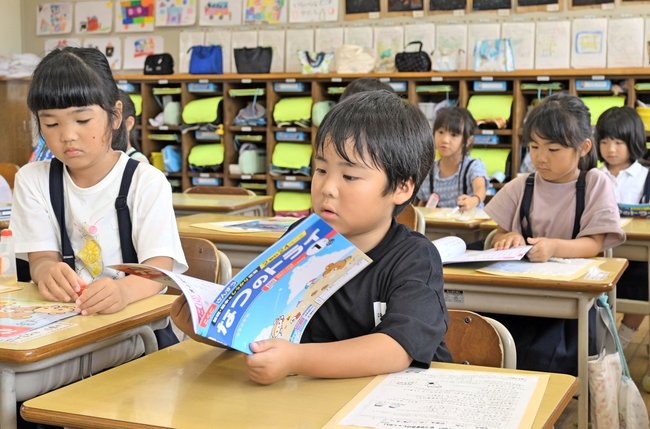 １学期の終業式を終え、夏休みの宿題を確認する児童＝２０２４年７月１９日、松江市東出雲町下意東の意東小学校